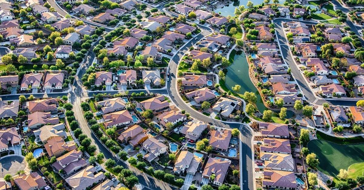 Community of houses in the suburbs of Arizona, forming a circular shape surrounding water.